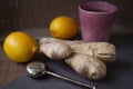 Ceramic mug of hot tea with tea strainer, ginger root and lemons on the table. Organic Alternative Therapy Concept.