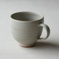 Ceramic mug with a matte, light gray surface featuring subtle horizontal ridges. The mu Royalty Free Stock Photo
