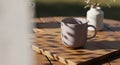 Ceramic mug on a wooden surface casts soft shadows. Warm sunlight highlight Royalty Free Stock Photo