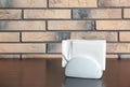 Ceramic napkin holder with paper serviettes on table near brick wall. Royalty Free Stock Photo