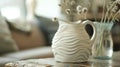 A ceramic pitcher with a handcarved texture resembling waves creating a tactile and visually pleasing element to the