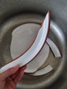 Ceramic plate broke apart. Failure in the kitchen during meal preparation. Dinner plate cracked into pieces. Hand holds broken