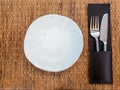 Ceramic plate. Empty white freeform shaped porcelain dish with knife and fork in leather case on mat Royalty Free Stock Photo