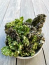 Kale chips, perfect snack, fresh kale leaves wooden background Royalty Free Stock Photo