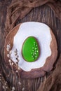 Ceramic plate, gingerbread Easter egg and willow branches on a dark background. Top view