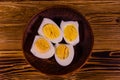 Ceramic plate with peeled boiled eggs on wooden table. Top view Royalty Free Stock Photo