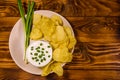 Ceramic plate with potato chips and glass bowl with sour cream o Royalty Free Stock Photo