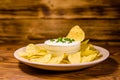 Ceramic plate with potato chips and glass bowl with sour cream o Royalty Free Stock Photo