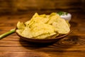 Ceramic plate with potato chips and glass bowl with sour cream o Royalty Free Stock Photo