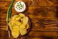 Ceramic plate with potato chips and glass bowl with sour cream o Royalty Free Stock Photo