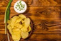 Ceramic plate with potato chips and glass bowl with sour cream o Royalty Free Stock Photo