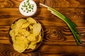 Ceramic plate with potato chips and glass bowl with sour cream o Royalty Free Stock Photo