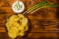 Ceramic plate with potato chips and glass bowl with sour cream o Royalty Free Stock Photo