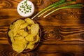 Ceramic plate with potato chips and glass bowl with sour cream on wooden table. Top view Royalty Free Stock Photo