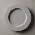 Ceramic plate with a small round indentation is centered on a Royalty Free Stock Photo