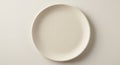A ceramic plate with a textured linen-like surface sits on a plain, light-colored Royalty Free Stock Photo