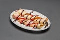 Ceramic plate with wrapped pancakes with chocolate and berry topping