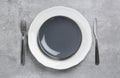 Ceramic plates, fork and knife on light grey table, flat lay Royalty Free Stock Photo