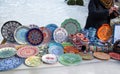 Ceramic plates, hand-painted with a dot pattern, are on the counter at the festive fair.
