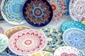 Ceramic plates, hand-painted with a dot pattern, are on the counter at the festive fair.
