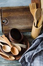 Ceramic plates, wooden or bamboo cutlery, vintage cutting board and towel in interior of kitchen