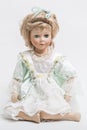 Ceramic porcelain handmade blond doll in white and green dress Royalty Free Stock Photo