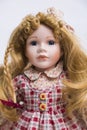 Ceramic porcelain handmade doll with long blond hair and plaid dress Royalty Free Stock Photo