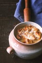 Ceramic pot with onion soup on the wooden table vertical Royalty Free Stock Photo