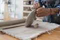 Potter sculptor cutting clay with the string in workshop for sale in retail store