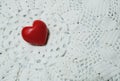Ceramic red heart on white lace knitted fabric. Crochet Favorite hobby, Valentine. Royalty Free Stock Photo