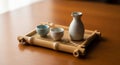 Ceramic sake set with two cups and a small pitcher, placed on a rectangular bamboo tray with Royalty Free Stock Photo