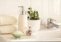 Ceramic soap, shampoo bottle, bowl with bath salt and white cotton towels on Blurred bathroom interior background with sink and