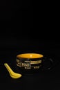 A ceramic soup bowl or soup mug with handle and a yellow soup spoon kept next to it Royalty Free Stock Photo