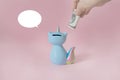 Ceramic souvenir toy money box kitten Korn blue with colorful rainbow tail with unicorn horn on pink background in