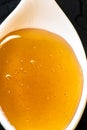 Ceramic spoon with honey on black Royalty Free Stock Photo