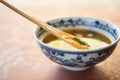 ceramic spoon resting in a bowl of hot and sour soup