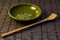 a ceramic spoon with wasabi paste on a bamboo mat