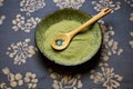 a ceramic spoon with wasabi paste on a bamboo mat