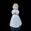 Ceramic statuette of a little girl isolated on black background. Royalty Free Stock Photo