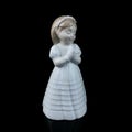 Ceramic statuette of a little girl isolated on black background. Royalty Free Stock Photo