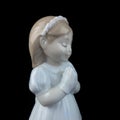 Ceramic statuette of a little girl isolated on black background. Royalty Free Stock Photo