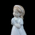 Ceramic statuette of a little girl isolated on black background. Royalty Free Stock Photo