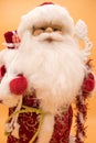 Ceramic statuette of Santa Claus in a red coat holding a staff  on yellow background Royalty Free Stock Photo