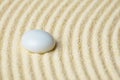 Ceramic stone on a surface of yellow sand close up