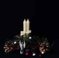 Ceramic stylized angel and four candles as symbol of Christmas, green pine branch and cones on black background. Symbolic concept