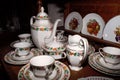 Ceramic tableware for coffee or tea, consisting of cups with plates and a tall jug