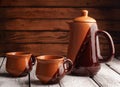 Ceramic tableware on a wooden background, a clay teapot and two cups, Royalty Free Stock Photo