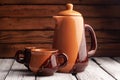 Ceramic tableware on a wooden background, a clay teapot and two cups, Royalty Free Stock Photo