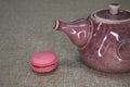 ceramic tea pot and a piece of macaroon Royalty Free Stock Photo