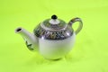 Ceramic teapot isolated on green background